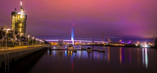 Illuminated bridge in city against sky