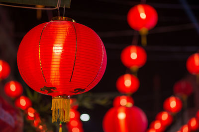 Low angle view of illuminated lanterns hanging at night