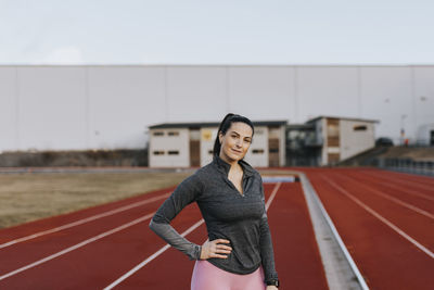 Young woman standing at running track