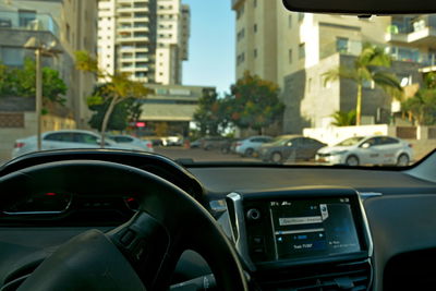 Car on road by buildings in city