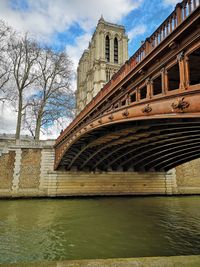 Arch bridge over river against buildings