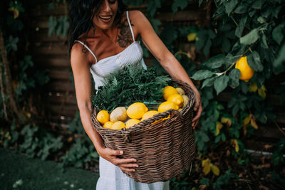 Young woman holding fruits in basket