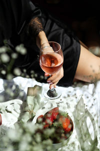 Close-up of hand holding a glass of rose wine