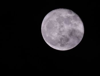 Low angle view of full moon against sky at night