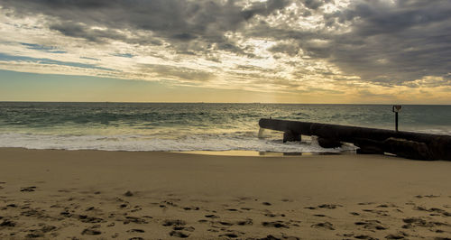 Scenic view of beach against sky during sunset