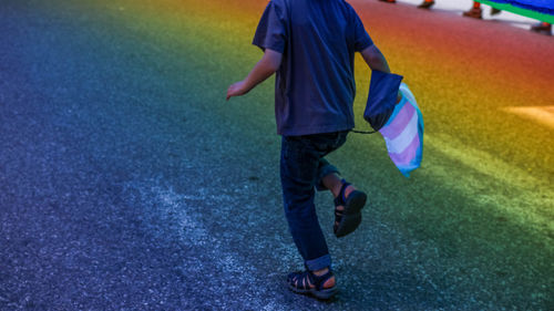 Low section of man walking on road