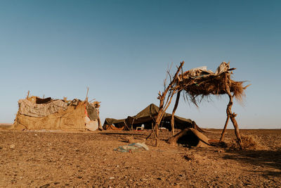 Traditional windmill on desert against clear sky