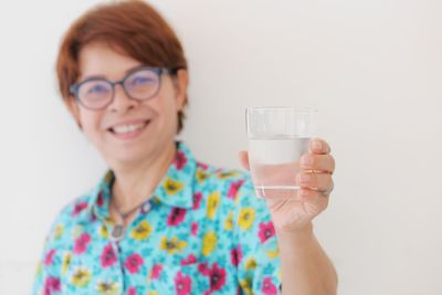 Portrait of a smiling young woman drinking glass
