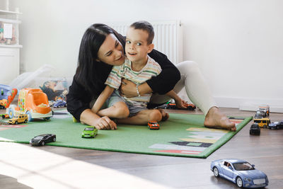 Kid with health problem playing toy cars with mother at home. child having cerebral palsy