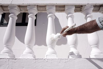 Cropped image of worker painting balustrade