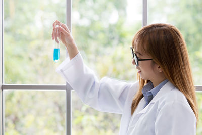 Female scientist examining chemical in laboratory