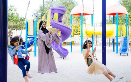 Mother with cheerful daughters enjoying at park