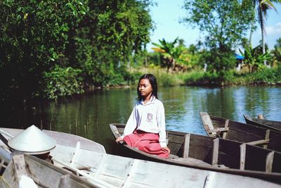 Portrait of woman by lake against trees