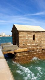 Built structure on beach against sky