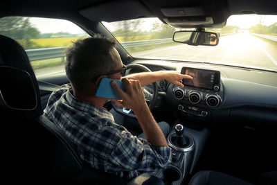 Man drive a car and use infotainment. driver male reading messages and make phone call while driving