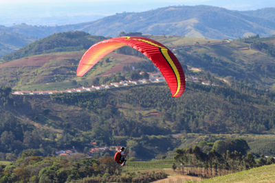 Person paragliding over mountains