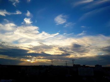 Silhouette cityscape against sky during sunset