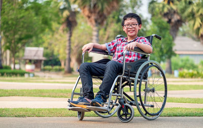 In the park, a child in a wheelchair. take a closer look at his steering wheel. medical concept .