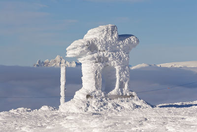 Built structure on snowcapped mountain against sky