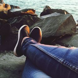 Low section of woman relaxing on rock