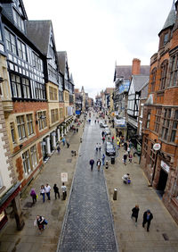 High angle view of people walking on street amidst buildings in city