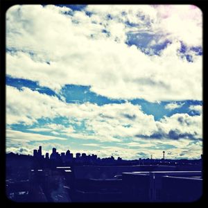 View of cityscape against cloudy sky