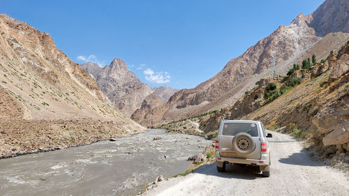 Road by mountains against blue sky