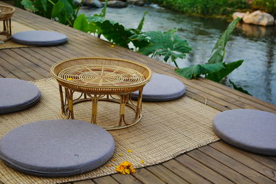 High angle view of empty chairs and table by lake