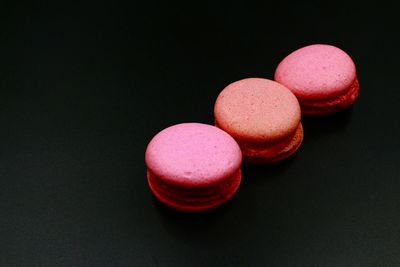 High angle view of pink candies on table against black background