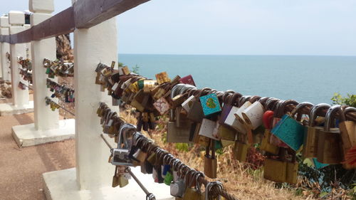 Close-up of padlocks on railing against sea