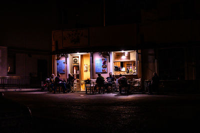 People in illuminated building at night