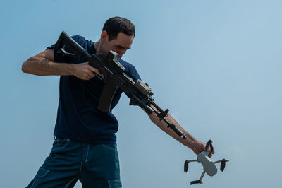 Side view of man standing against clear sky