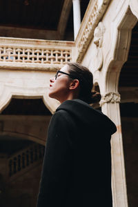 Side view of man looking through window