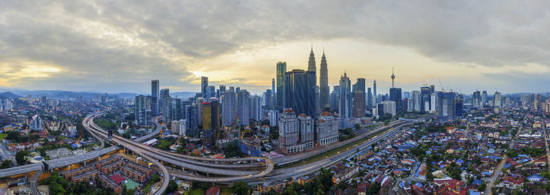 High angle view of modern buildings against cloudy sky