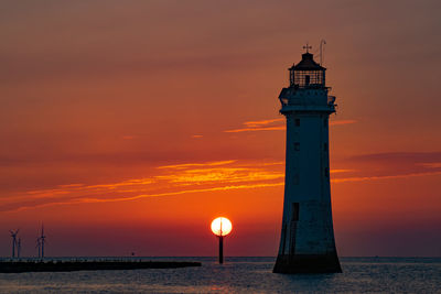 Lighthouse against sky during sunset