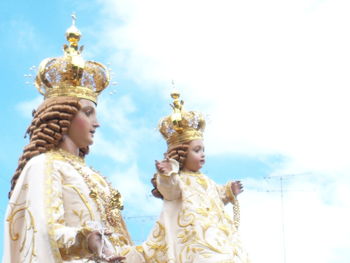 Low angle view of statue against temple building against sky