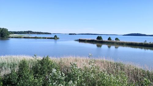 Scenic view of lake against clear blue sky