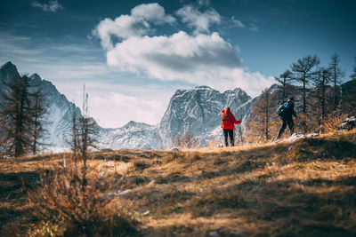 People walking on snowcapped mountain against sky