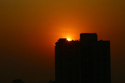 Low angle view of silhouette buildings against sky during sunset