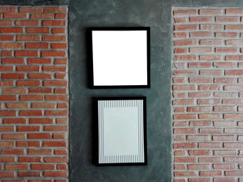 Empty picture frames hanging on brick wall