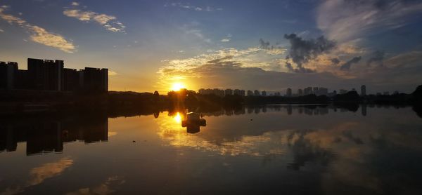 Scenic view of silhouette buildings against sky during sunset