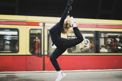 Full length of woman dancing on train at railroad station