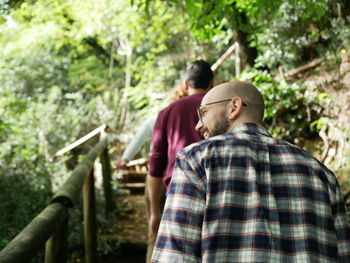 Rear view of men walking in forest