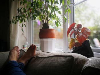 Low section of woman on sofa at home