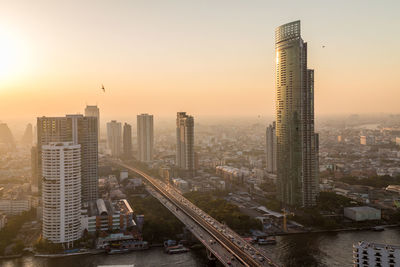 Aerial view of cityscape against sky during sunset