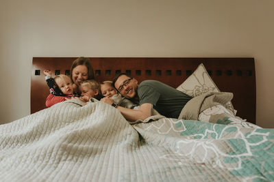 Portrait of young couple lying on bed at home