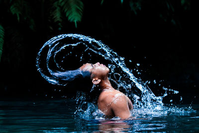 Portrait pose of man splashing water with his hair.
