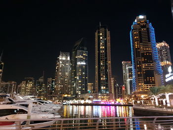 Illuminated modern buildings against sky at night