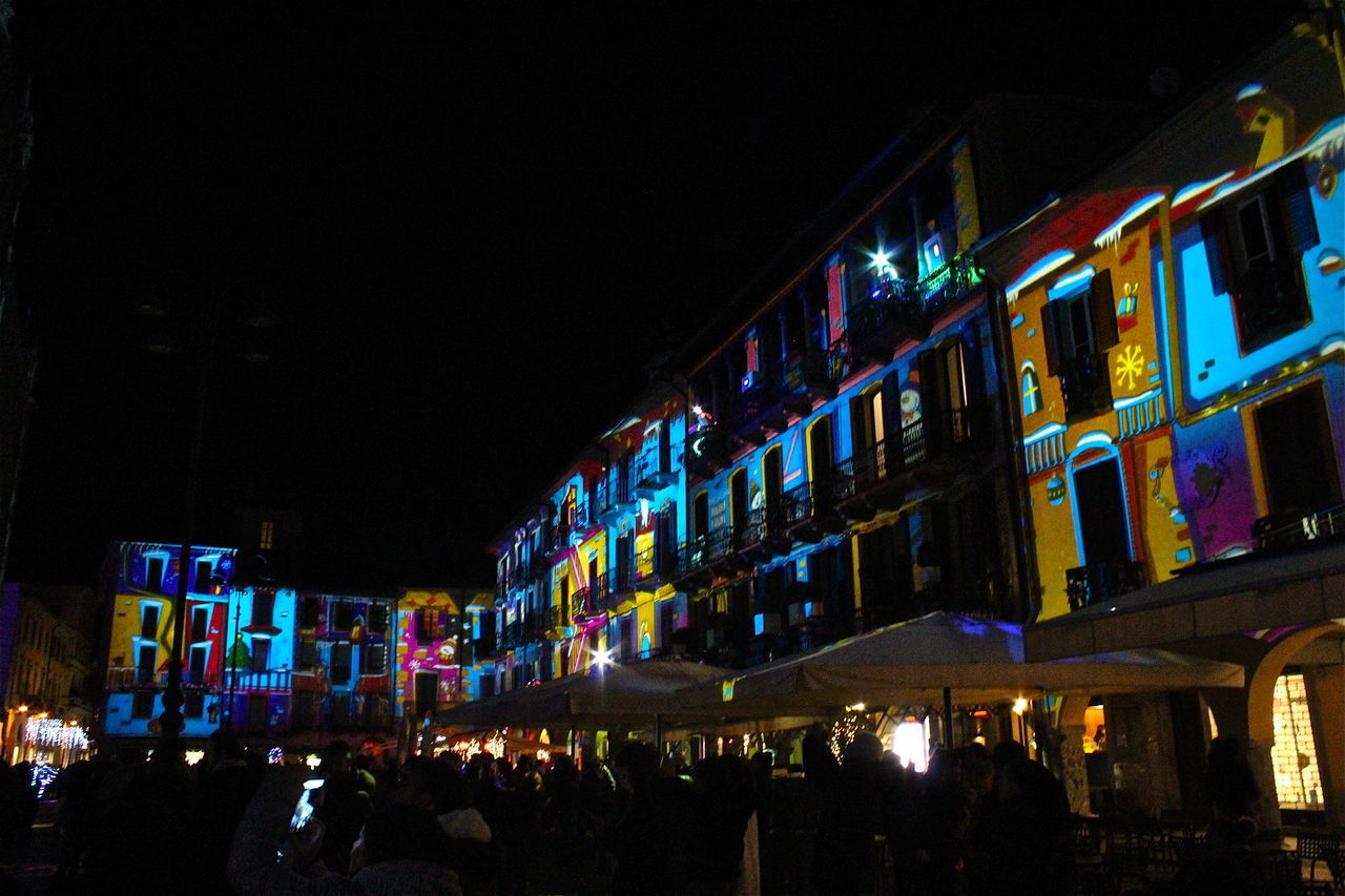 PEOPLE ON ILLUMINATED BUILDING AT NIGHT