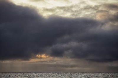 Scenic view of sea against storm clouds